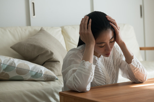 頭が重くて体調不良の女性の様子